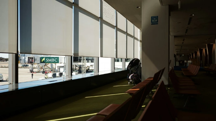 Airport waiting area with large windows overlooking tarmac